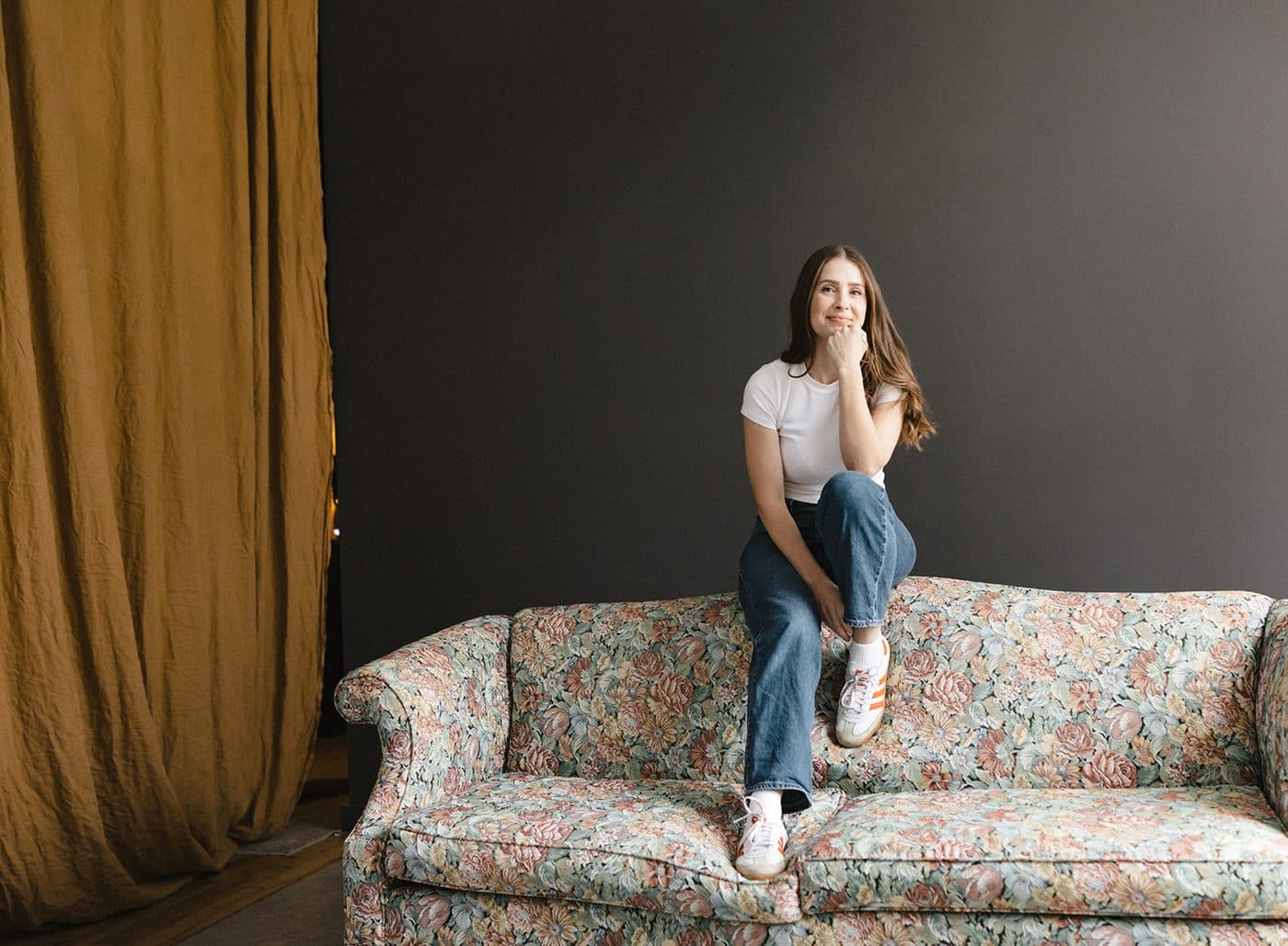 Sara sitting on a floral sofa